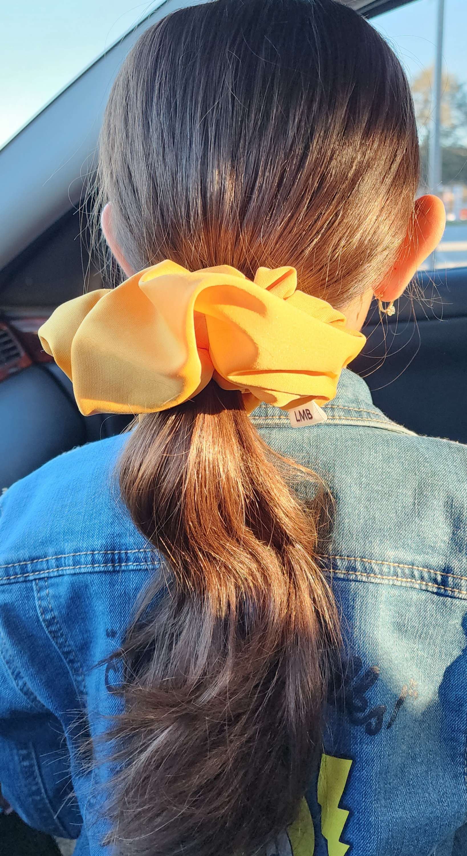 XL knit scrunchie in yellow holding long hair in a ponytail
