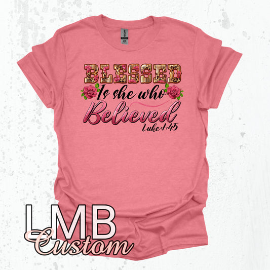 Pink adult unisex t-shirt with "Blessed is she who Believed Luke 1:45" floral text design