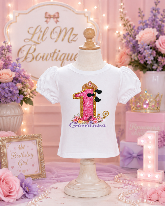 White t-shirt with pink number '1' and name on a mannequin against a decorative background.