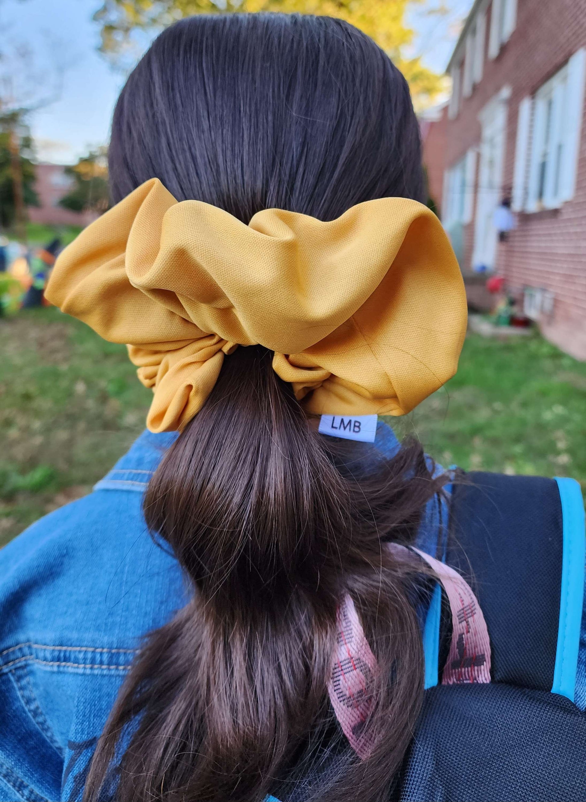 XL knit scrunchie in mustard yellow on dark hair outdoors